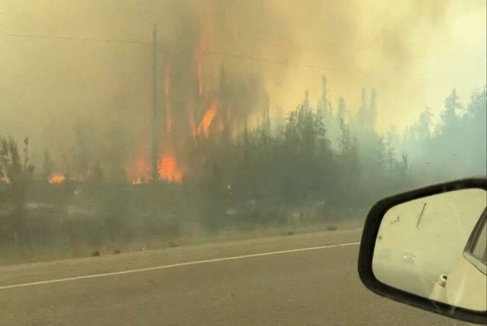 This screengrab from a video provided by Jordan Straker shows vehicles driving on the freeway as people evacuate from Yellowkife, Northwest Territories, Canada, on Aug 16, 2023. (Photo by Jordan Straker / UGC / AFP)