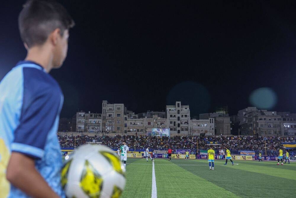A ball boy watches the final match of a local football tournament at the municipal stadium in Syria's rebel-held city of Idlib, on Aug 18, 2023. (Photo by OMAR HAJ KADOUR / AFP)