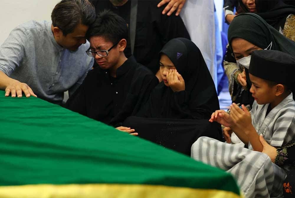 The three children of the late pilot Heikal Aras Abdul Azim; Rafael Dzulqairy, Suri Balqish and Daniel Zulqarnain shed tears as their father's remains arrived at Desa Pinggiran for burial at the Precinct 20 Muslim Cemetary in Putrajaya today.