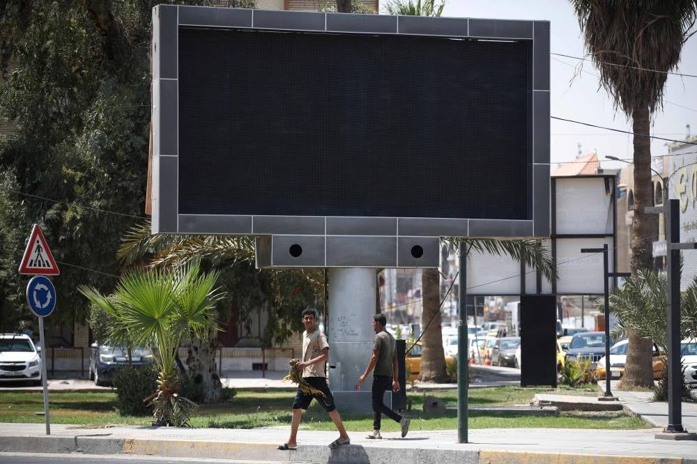 Vehicles drive past a shut advertisement screen at the Uqba Bin Nafia square in Baghdad on August 20, 2023. Iraqi authorities ordered the shutdown of LED advertisement screens installed across Baghdad after a hacker managed to show a pornographic film on one, security forces said on August 20, announcing the arrest of a suspect. - Photo by AFP