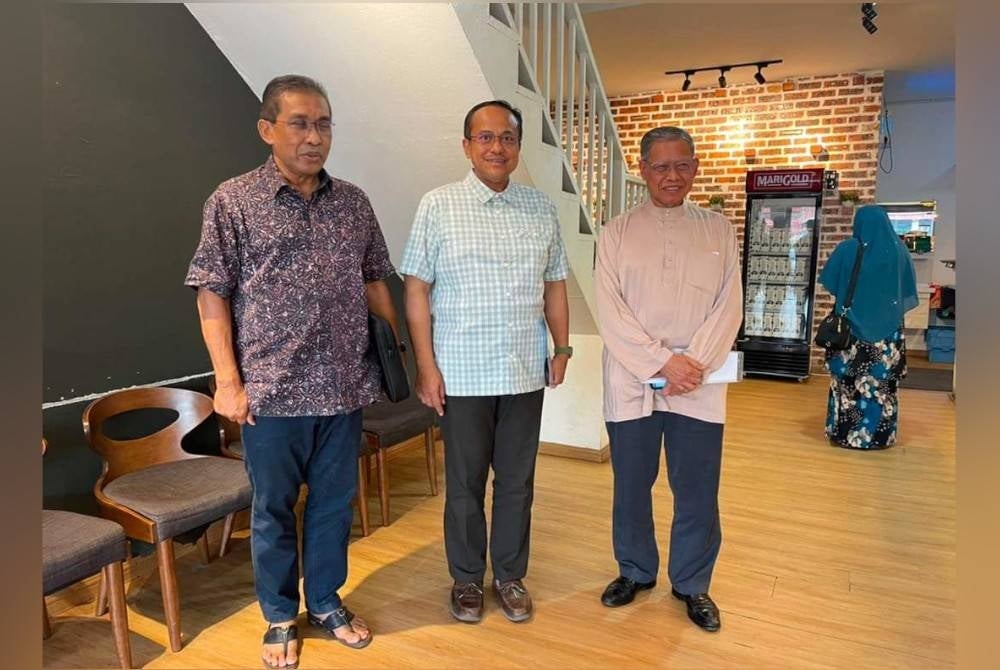 Samsuri (centre) with Mustapa (right) at a meeting on Sunday. - Facebook
