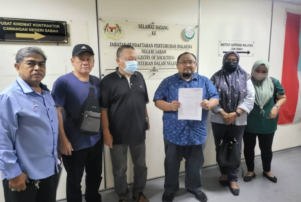 Zulfikar (third from the right) displays the report that was submitted to RoS for an investigation to be conducted concerning the Umno Kota Kinabalu division.