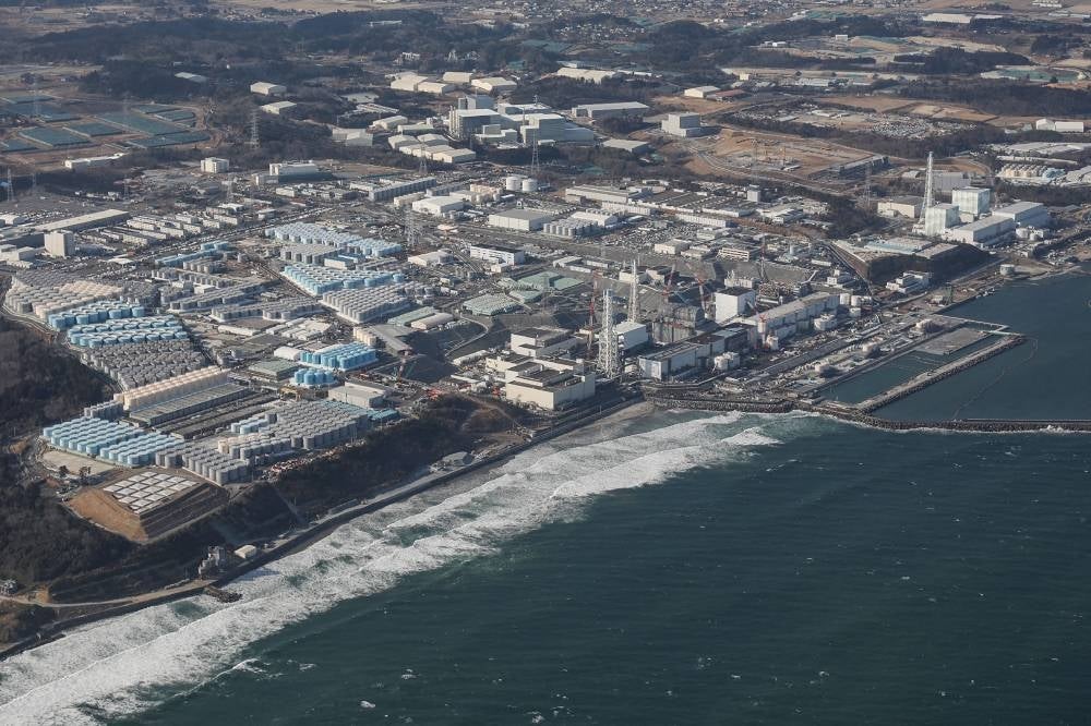 This aerial picture taken by Jiji Press on Feb 14, 2021 shows a view of TEPCO's crippled Fukushima Daiichi Nuclear Power Plant as well as tanks (L) used for storing treated wastewater, along the coast in Okuma, Fukushima prefecture. - Photo by JIJI Press / AFP / Japan OUT