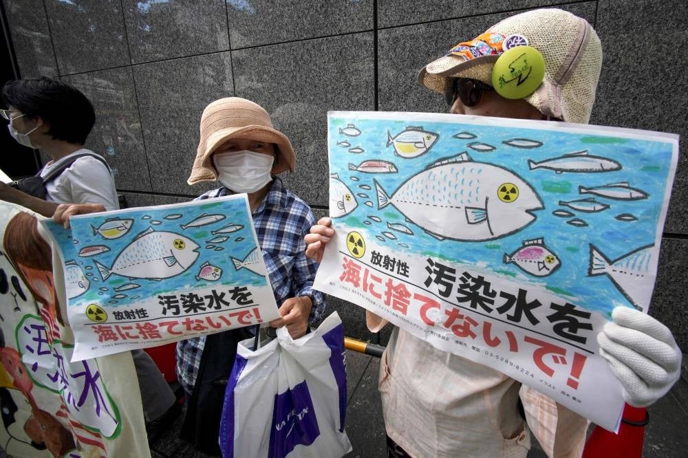 Protesters hold signs reading "Don't throw radioactive contaminated water into the sea!" as they take part in a rally outside the Tokyo Electric Power Company (TEPCO) headquarters building in Tokyo. Photo by Kazuhiro Nogi/AFP