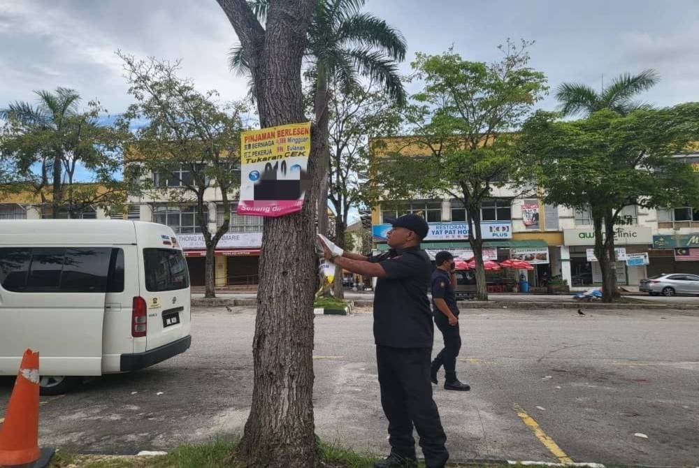 MBSA enforcers taking down illegal advertisements at a location under the supervision of local authority (PBT).