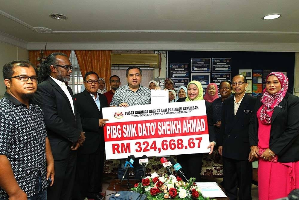 Anthony (fourth from left) handing over a cheque replica to the SMK Dato Sheikh Ahmad principal Datin Ramadhawati Wahab on Saturday.