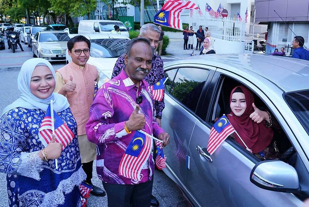Sivakumar distributing flags at the Semarak Merdeka: 66th National Day Celebration organised by the Human Resource Development Corporation (HRD Corp) on Monday.
