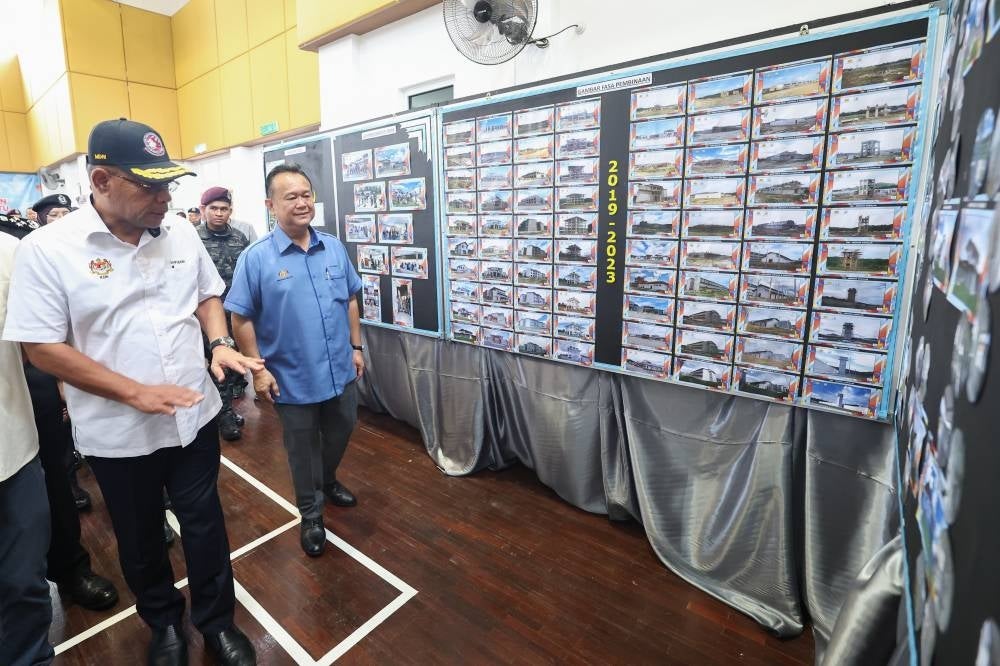 Saifuddin looking at the pictures of Lahad Datu prison's construction process. Photo by Bernama
