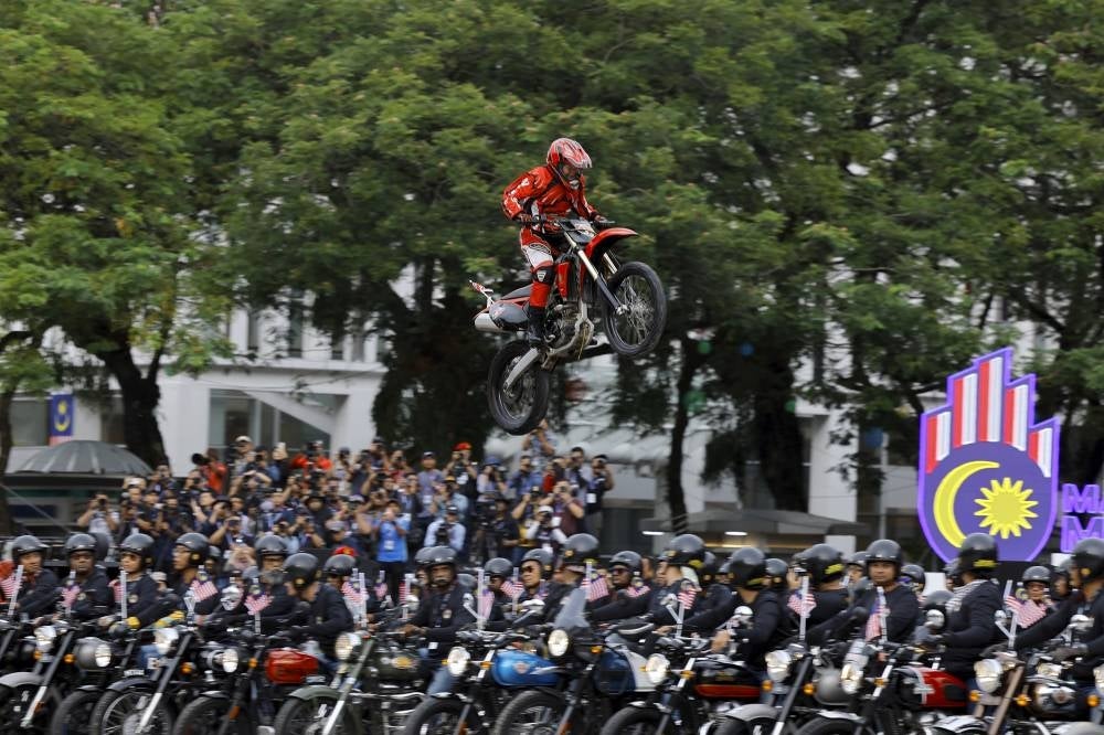Sergeant Saidatul Husna Kamarudin she successfully jumped over 66 Royal Enfield motorcycles on her Scrambler during the 2023 National Day parade in Putrajaya today. Photo by Bernama