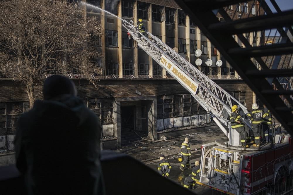 Firefighters work at the scene of a fire in Johannesburg on Aug 31, 2023. More than 70 people have died in a fire that engulfed a five-storey building in central Johannesburg on Aug 31, 2023, the South African city's emergency services said. - (Photo by Michele Spatari / AFP)