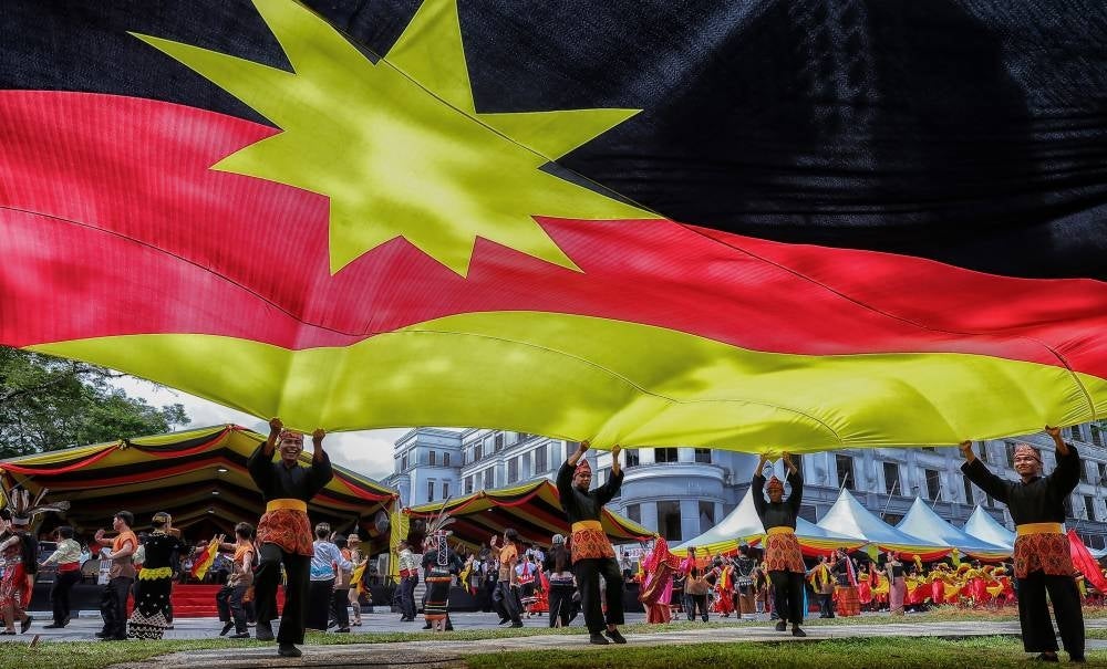 Participants waved the giant Sarawak flag at the 60th Anniversary Rally and Parade - photo by Bernama
