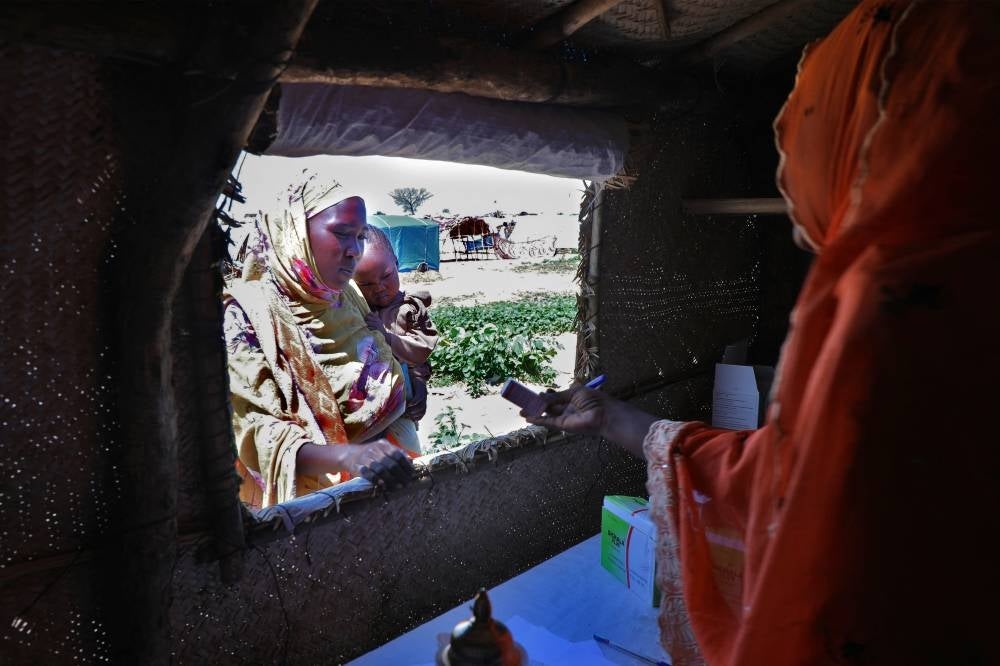 A refugee from the Sudan war collects medicine from a makeshift pharmacy at the camp. - (Photo by MOHANED BELAL / AFP)
