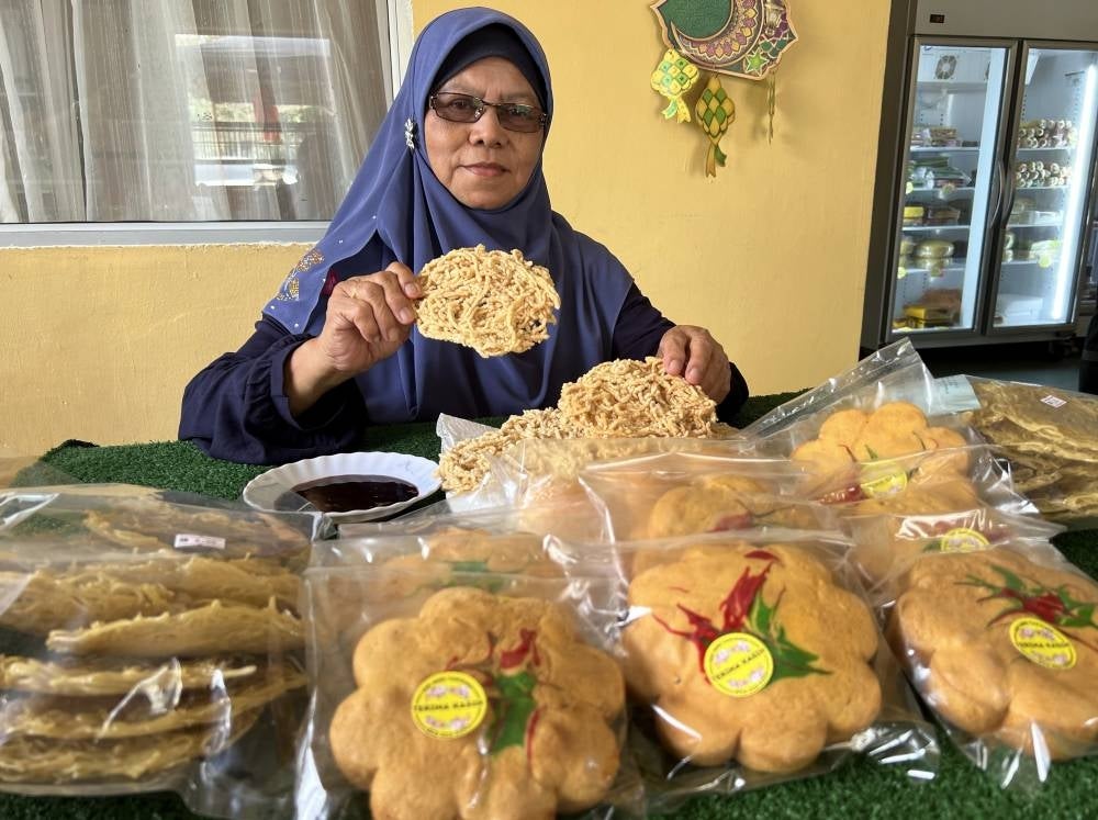 Entrepreneur Rawdiah Daud showing off the food she sold during the Simpang Jeram by-election campaign period. - BERNAMA PIX