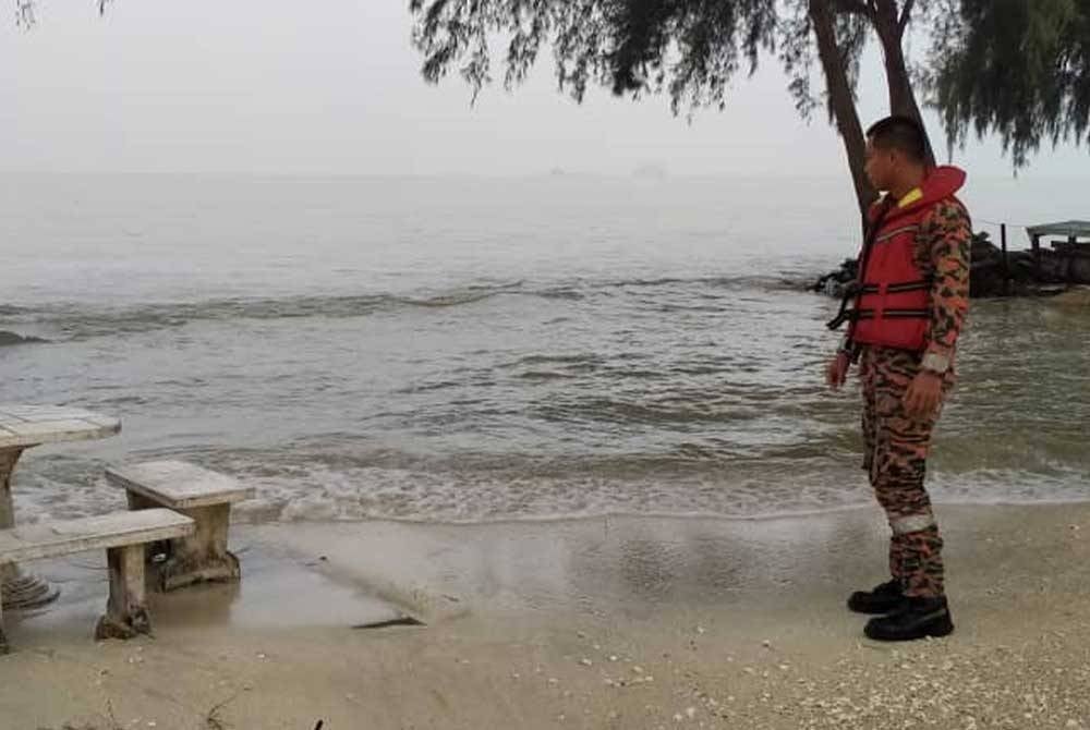 The firefighter was monitoring the phenomenon of a high tide at Pantai Remis Jeram on Sunday.
