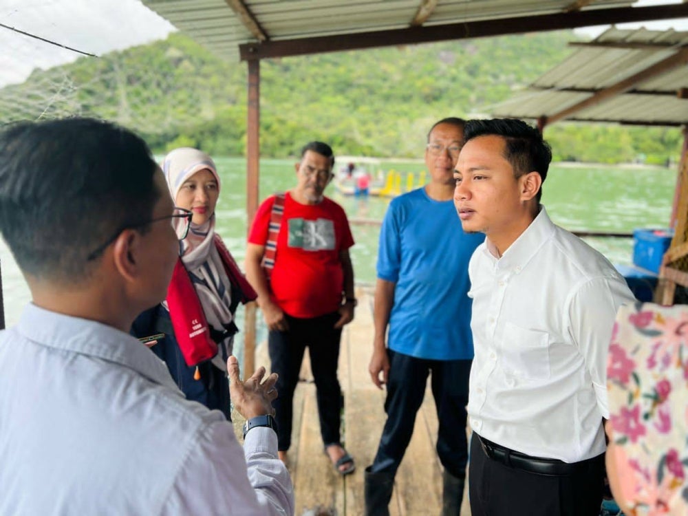 State Agrotechnology, Food Security and Cooperative Development Committee chairman Fahmi Zainol (left) visiting the fisheries owned by Moh Yok who suffered losses of RM500,000 after a 15 metric tonne of fish died due to the ‘red water’ phenomenon.