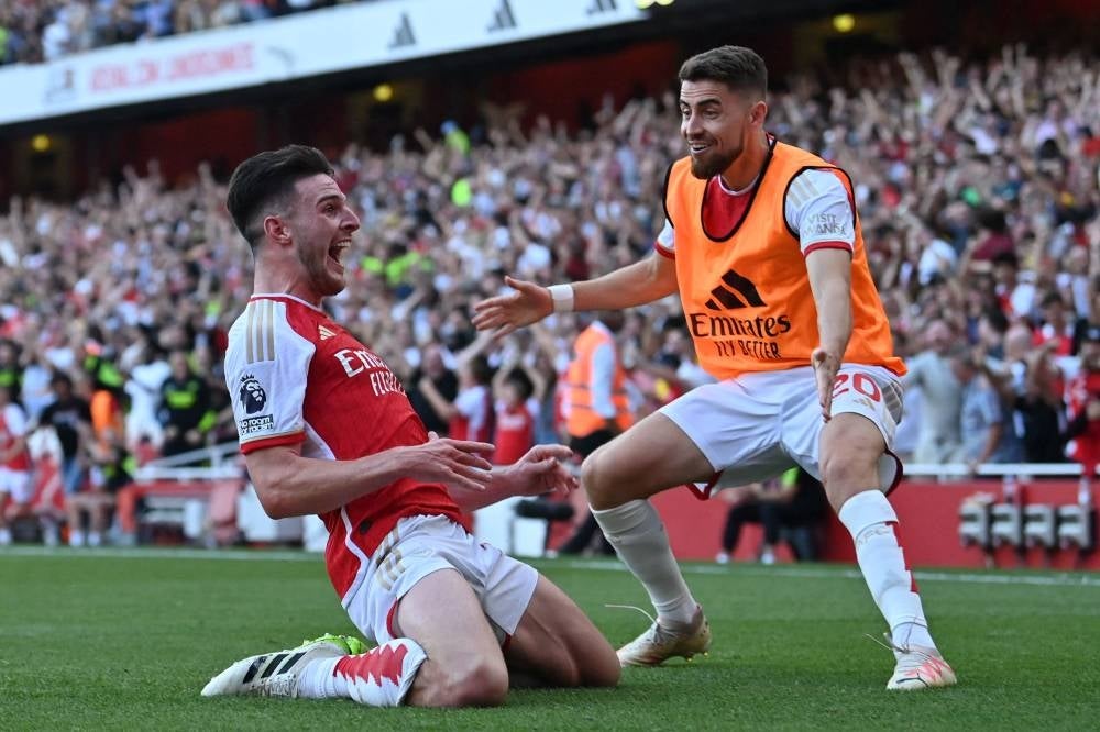Arsenal's English midfielder #41 Declan Rice celebrates with Arsenal's Italian midfielder #20 Jorginho (R) after scoring their late second goal during the English Premier League football match between Arsenal and Manchester United at the Emirates Stadium in London on September 3, 2023. - Photo by AFP