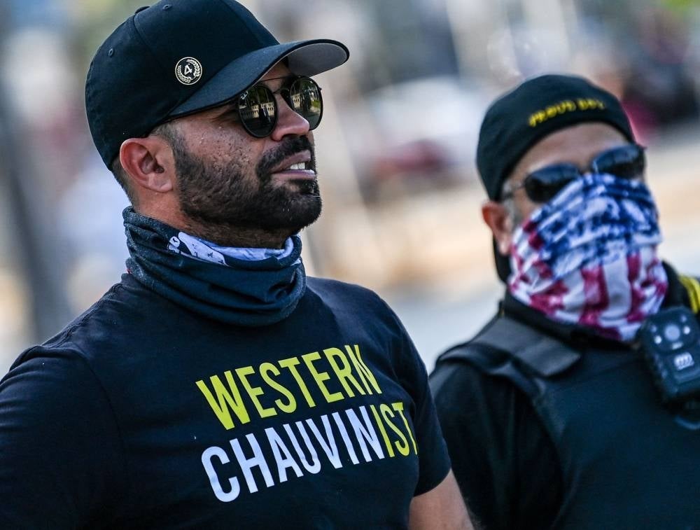 Leader of the Proud Boys Enrique Tarrio (L), wearing a shirt supporting Derek Chauvin, joins a counter-protest where people gathered to remember George Floyd on the one-year anniversary of his death at the hands of Minneapolis police officer, including Chauvin, in Miami on May 25, 2021. - FILE PIX by AFP