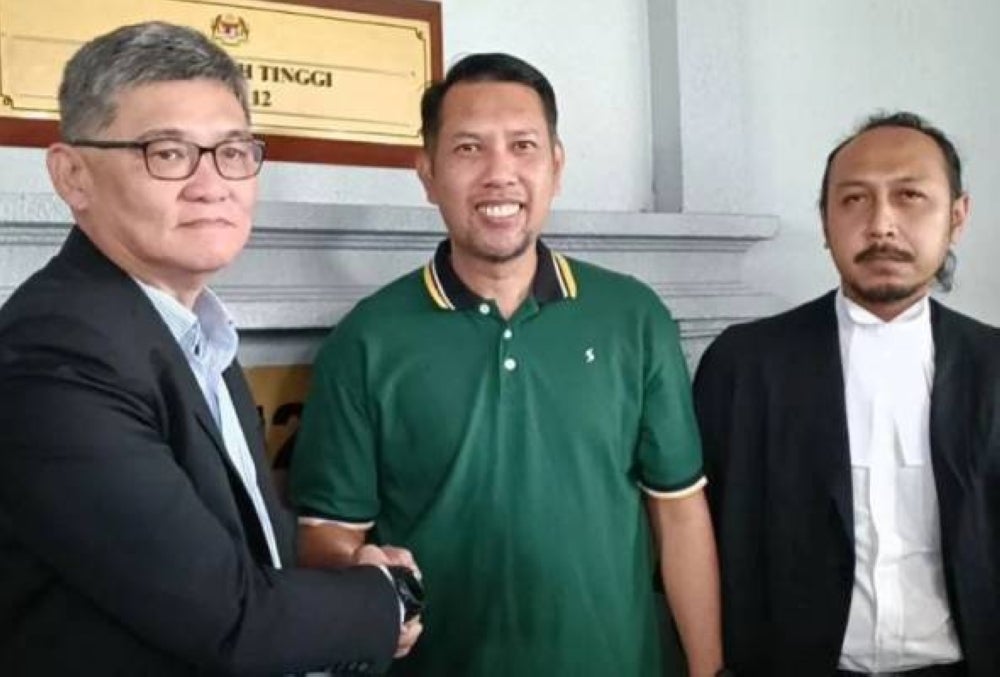 Roslin (centre) shaking hands with Goh outside the Kuala Lumpur High Court on Wednesday.