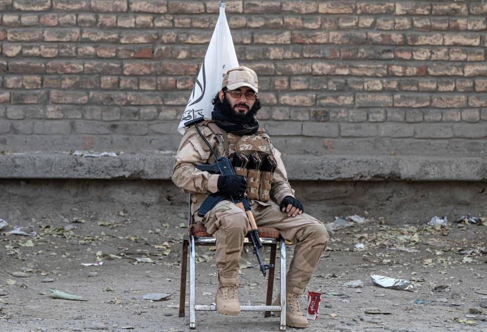 A Taliban security personnel sits on a chair along the roadside in Kabul on September 7, 2023 - AFP 