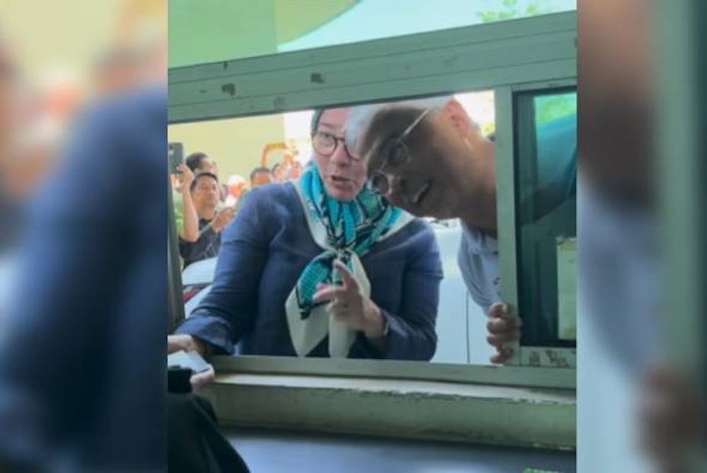 The King and the Queen handing over their passports to the immigration officer for stamping. - Photo: INSTAGRAM / ISTANA NEGARA