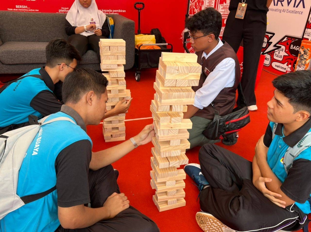 Students participating in Giant Jenga game at Sinar Daily booth in Karnival Pendidikan Sinar Bestari at Karangkraf headquarters 