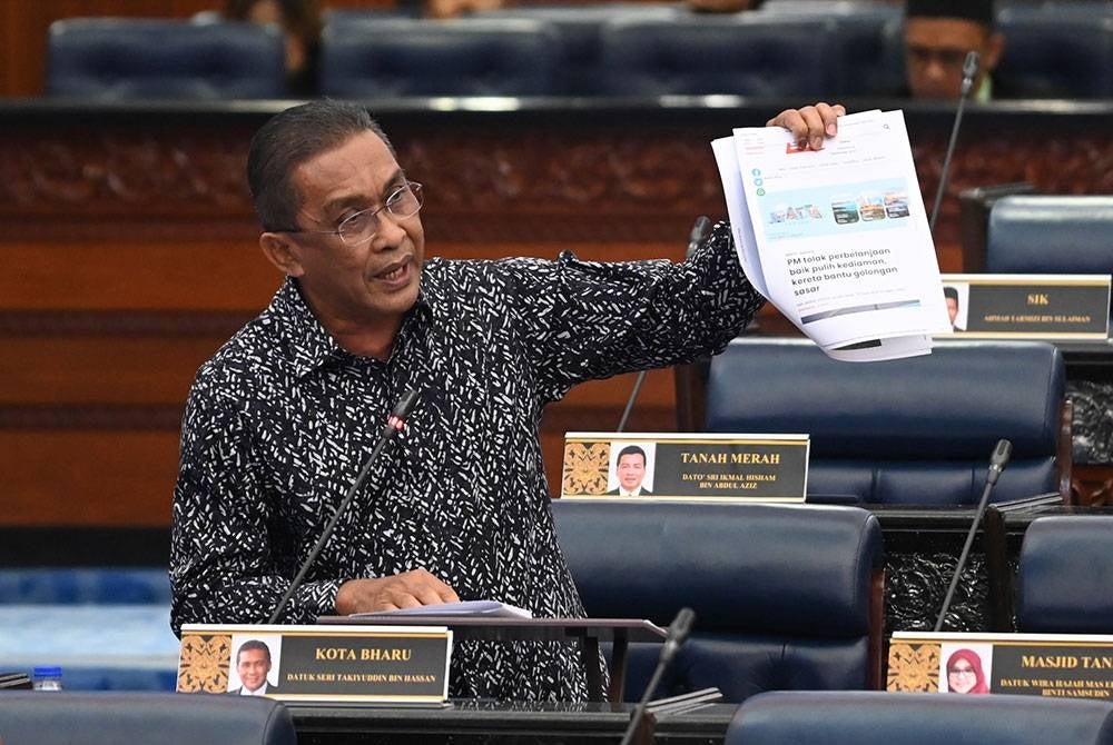 Takiyuddin showing a Sinar Harian report that quoted the Prime Minister's speech. - Information Department