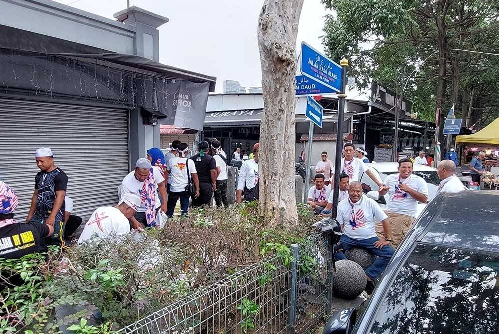 A group of men in white gathering near Masjid Jamek Kampung Baru today.