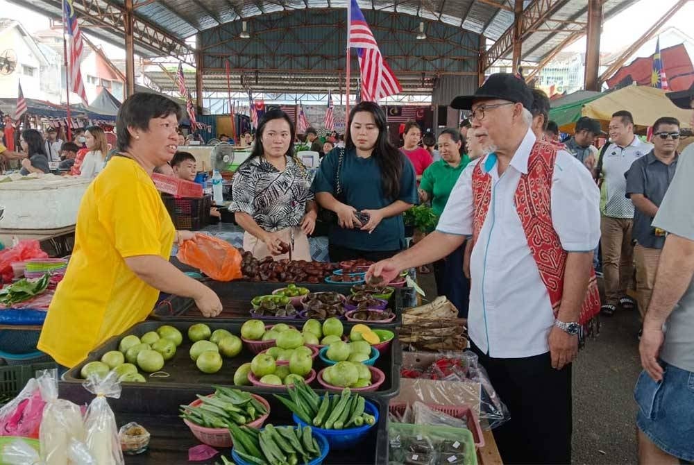 Hassan meting with vendors after the Malaysia Day Celebration Ceremony at Johor Borneo Market in Pasir Gudang on Saturday.