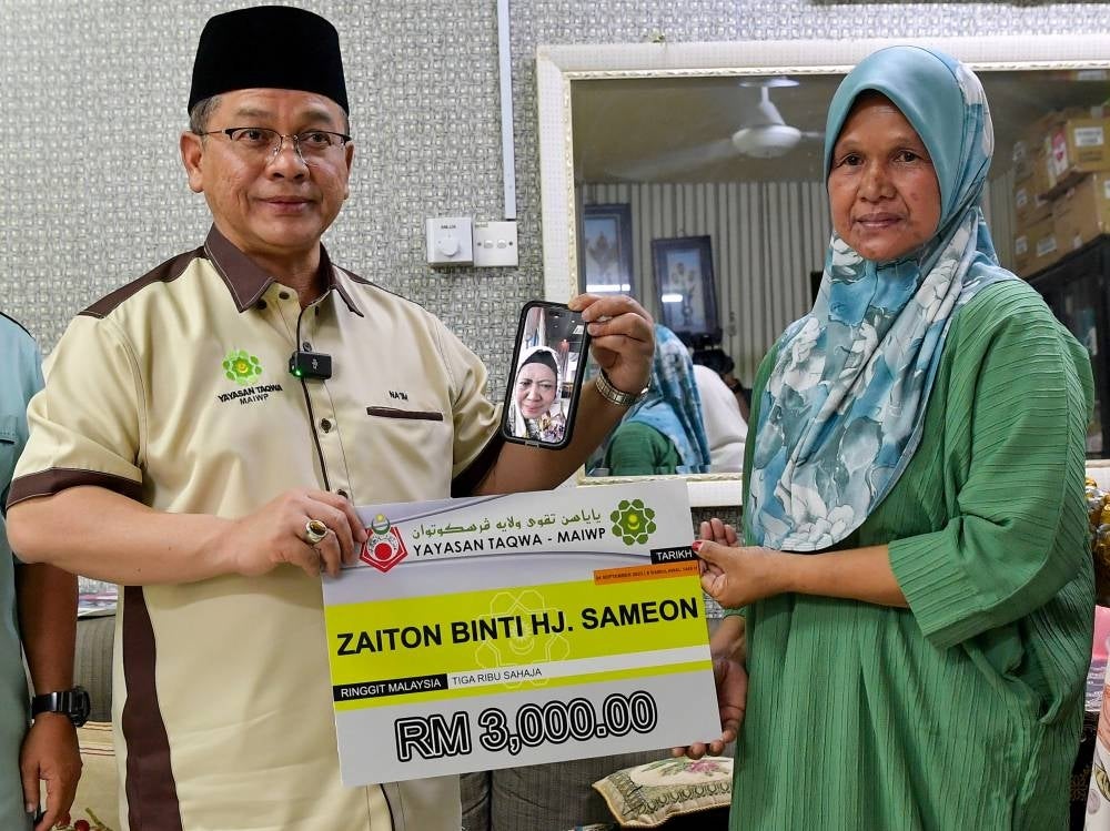 The aid of RM3,000 in cash, thanks to the cooperation of Yayasan Taqwa with MAIWP was presented by the Minister in the Prime Minister's Department (Religious Affairs) Datuk Dr Mohd Na'im Mokhtar to members of the singer's foster family. - Photo by Bernama
