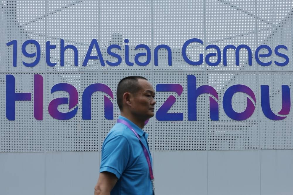 A Volunteer is seen passing by 19th Asian Games Hangzhou billboard at the Xiaoshan Guali Sports Centre. - Photo by Bernama