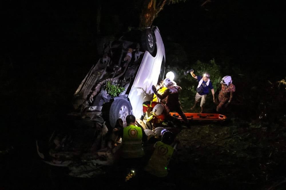 A Singaporean woman died while 10 others were injured when a tourist van skidded before plunging into an over six-metre deep ravine at Bukit Genting, here, last night. - Photo by Bernama
