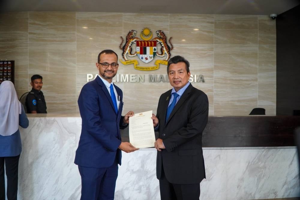 Ikmal (right) handing over the explanation memo to Nizam.