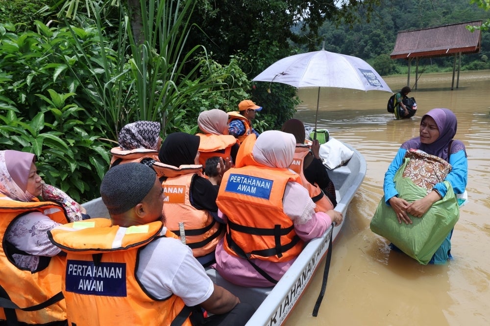 Kota Setar Civil Defense Force officers (APM) transporting flood victims from Kampung Bukit, Mukim Derang to the flood evacuation center here.Continuous rain caused low-lying areas in Mukim Derang to be flooded, including Kampung Bukit and Kampung Baru. BERNAMA PHOTO