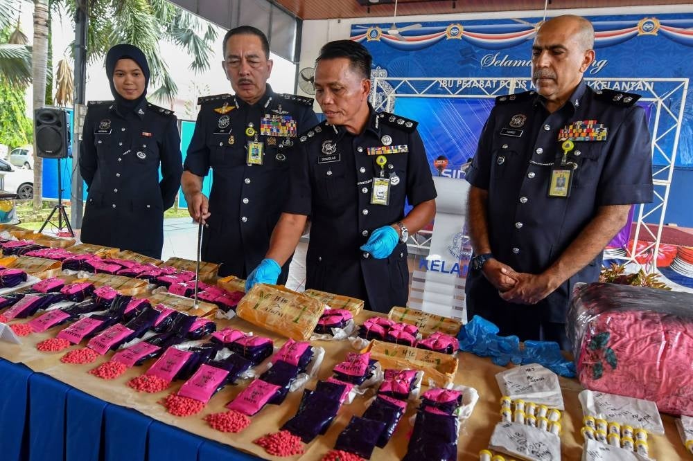 Kelantan police chief Datuk Muhamad Zaki Harun (two, left) said the drugs involved were 96,000 yaba pills and 230 bottles of heroin estimated to weigh 1.4 kilogrammes.- Photo by Bernama