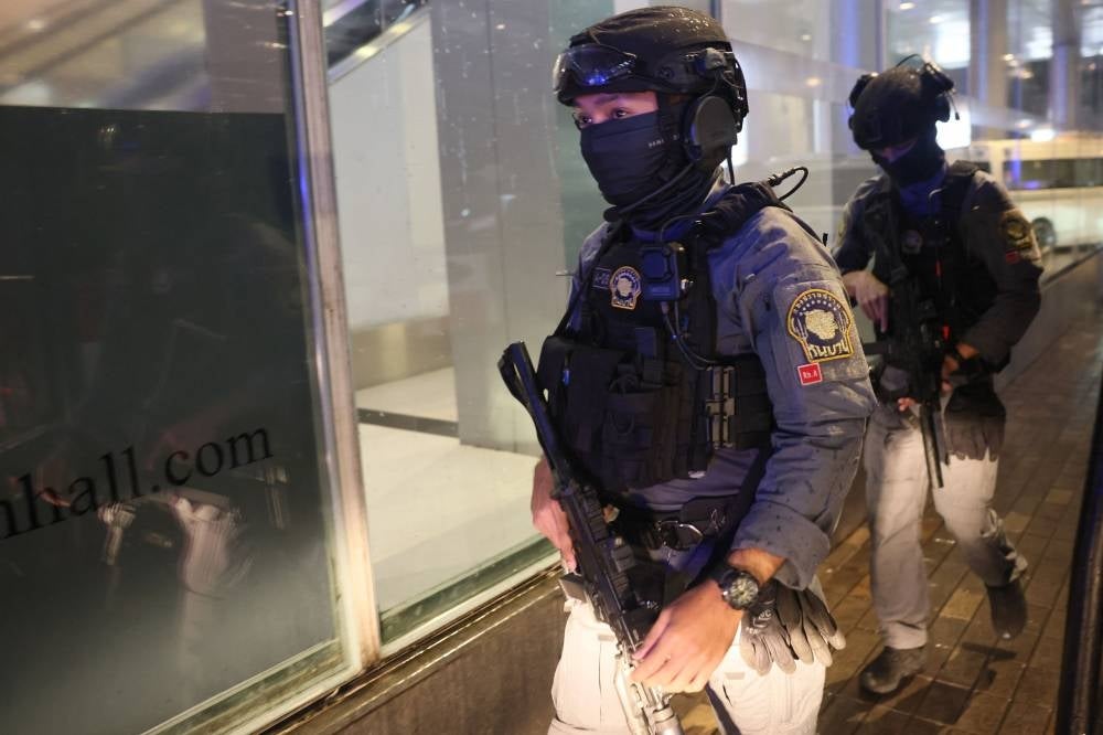 Armed police walk along the exterior of Siam Paragon shopping centre in Bangkok on October 3, 2023, following a shooting incident in the mall - AFP 