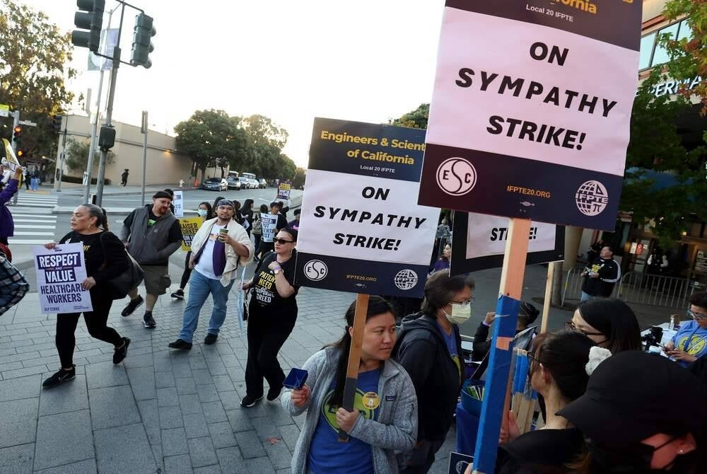 Striking Kaiser Permanente workers hold signs as they march in front of the Kaiser Permanente San Francisco Medical Center on October 04, 2023 in San Francisco, California. (Photo by JUSTIN SULLIVAN / GETTY IMAGES NORTH AMERICA / Getty Images via AFP)