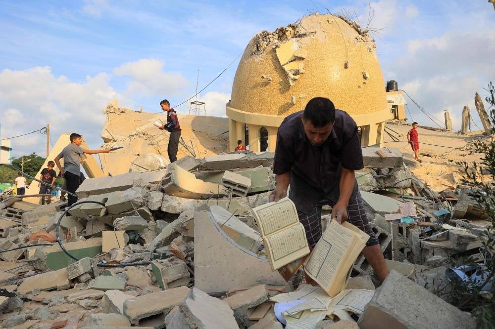 People examine the ruins of a mosque destroyed in Israeli airstrikes in Khan Yunis, southern Gaza Strip, on October 8, 2023. - Photo by AFP