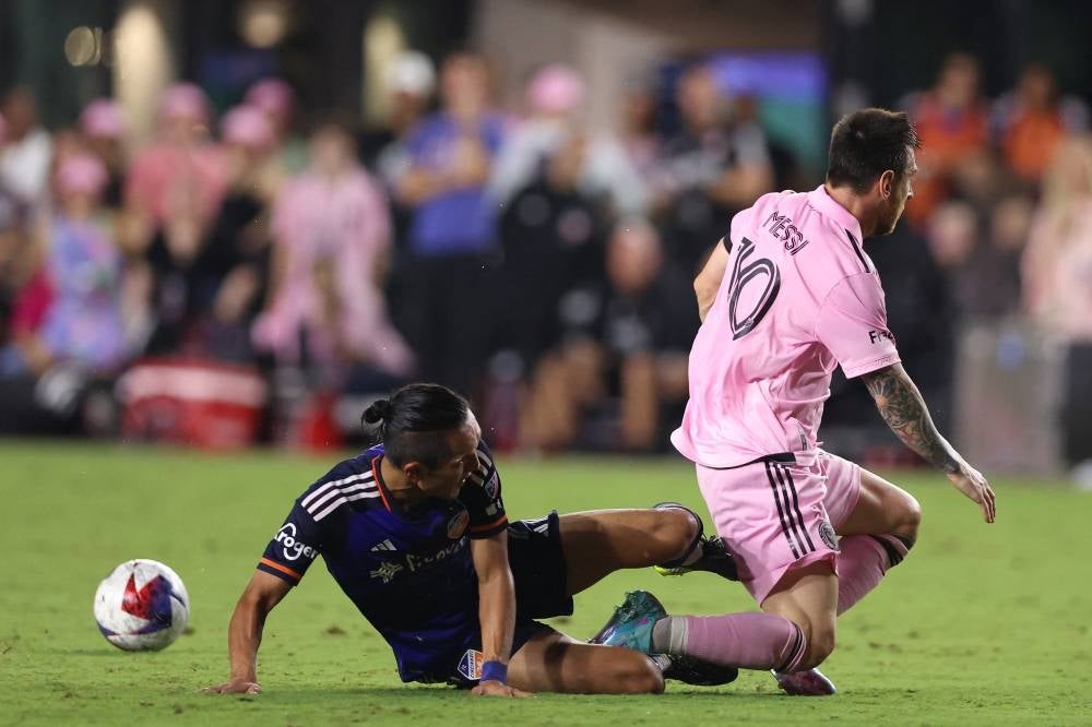 Lionel Messi #10 of Inter Miami CF is tackled by Yuya Kubo #7 of FC Cincinnati during the second half at DRV PNK Stadium on October 07, 2023 in Fort Lauderdale, Florida. - Photo by AFP