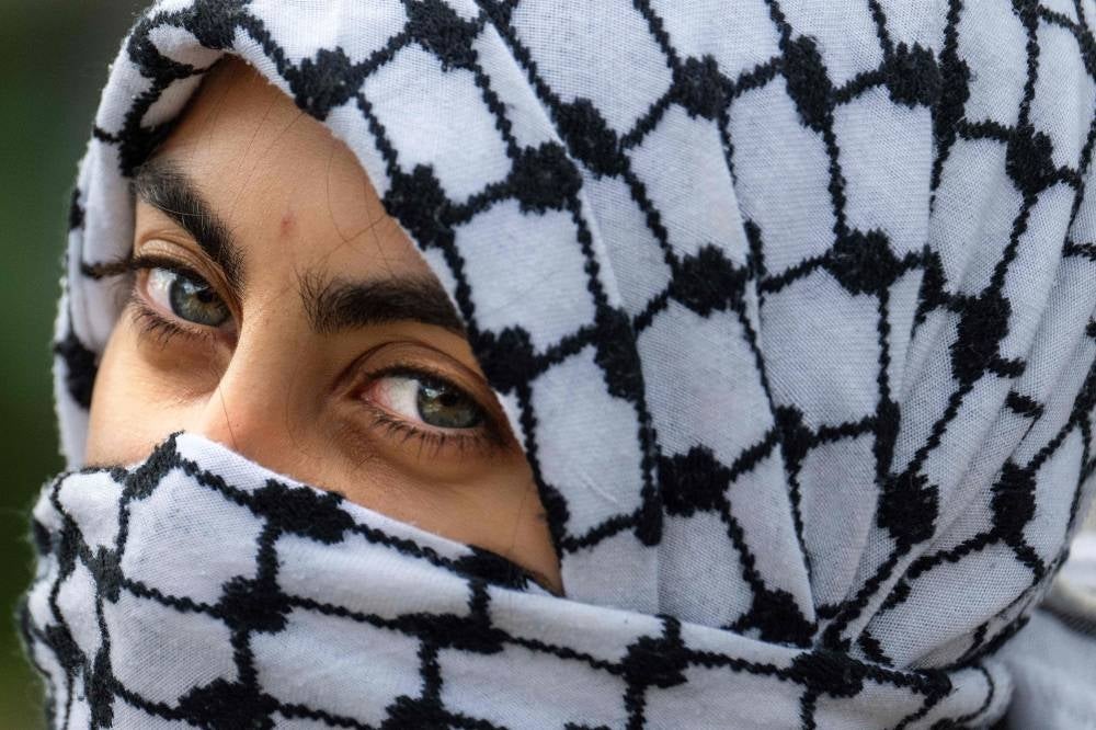 A demonstrator wears a keffyieh during a protest outside the White House in Washington, DC, on Oct 8, 2023 as crowds rally in support of Palestinians after the Hamas Palestinian militant group launched assault on Israel. (Photo by Jim WATSON / AFP)