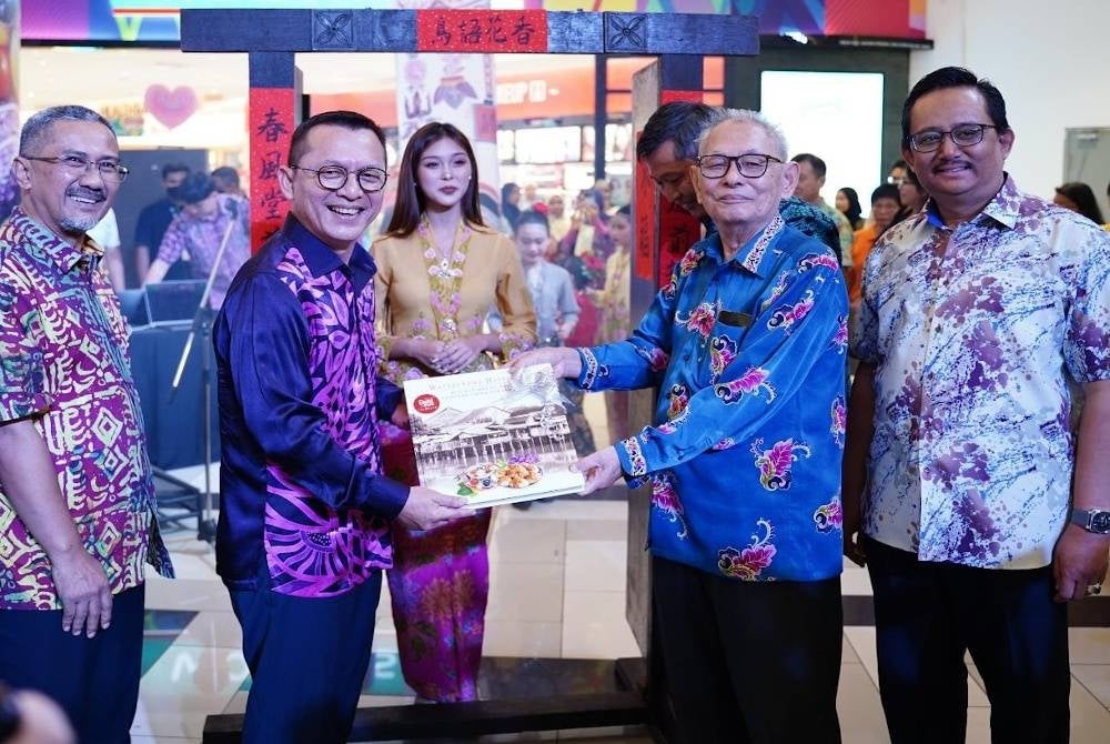 Terengganu Chinese Peranakan Association president Dr Wee Tiong Wah (second from the right) handing a book on the uniqueness of the community to Razali Idris (Second from the left) in conjunction with the 2023 Terengganu Chinese Peranakan Festival at KTCC - BERNAMA