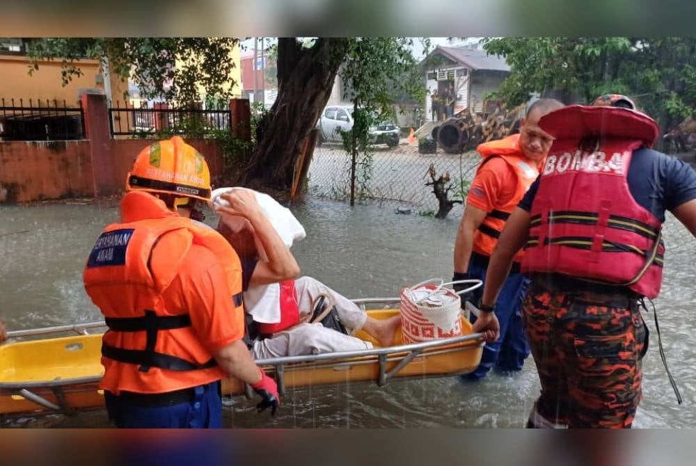 Firemen saving flood victims in Kampung Baru on Tuesday - FILE PIX
