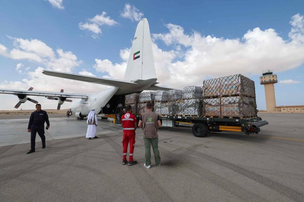 Staff members unload aid for the Palestinian Gaza Strip from an Emirates cargo plane on the tarmac of Egypt's el-Arish airport in the north Sinai Peninsula on October 19, 2023, amid the ongoing battles between Israel and the Palestinian group Hamas. - Photo by AFP