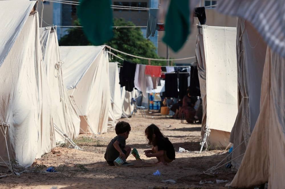 Children play among tents set up for Palestinians seeking refuge on the grounds of a United Nations Relief and Works Agency for Palestine Refugees (UNRWA) centre in Khan Yunis in the southern Gaza Strip. Photo by Mahmud Hams/AFP