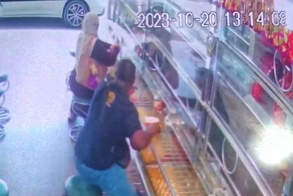 The screenshot from the CCTV recording of the premises which shows the suspect the suspect grabbed the necklace and ran out of the store, fleeing.