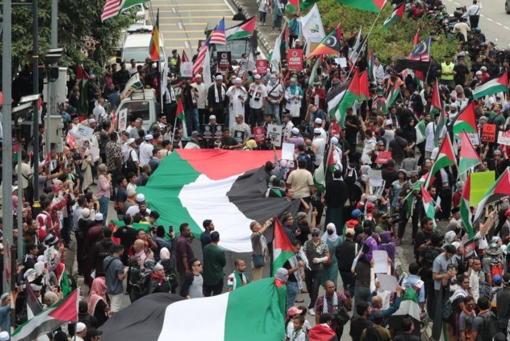 Giant Palestinian flags being carried by dozens of participants of the Solidarity with Gaza and Palestine Rally in Kuala Lumpur today. - Photo: FACEBOOK