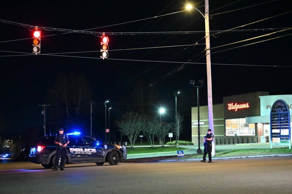 Police officers stand in the area near a recycling plant where the body of shooting suspect Robert Card was allegedly found 12km from Lewiston, Maine. Photo by Angela Weiss/AFP