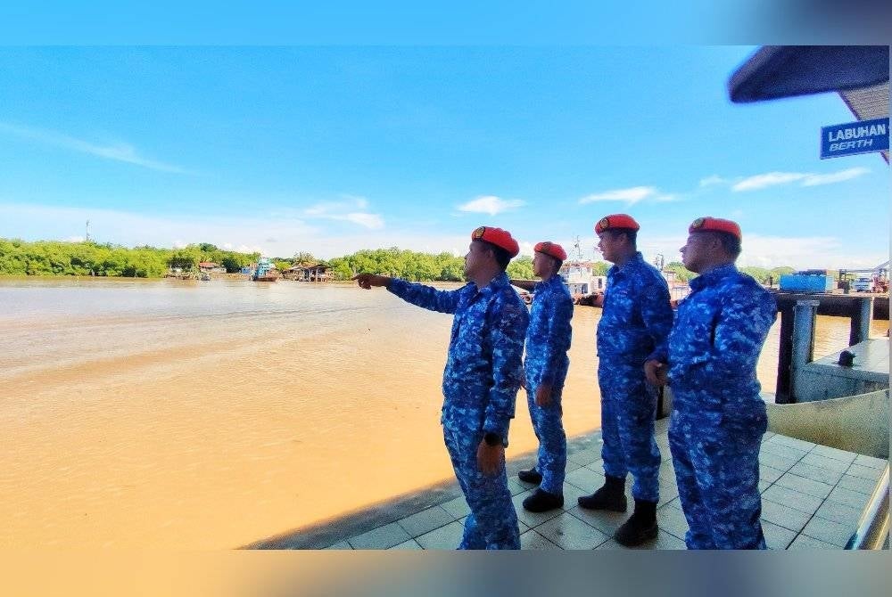 Kedah APM director, Lieutenant Colonel (PA) Zairil Anuar Zulmuji (left) with personnel monitoring a high tide at Kuala Kedah Jetty today.