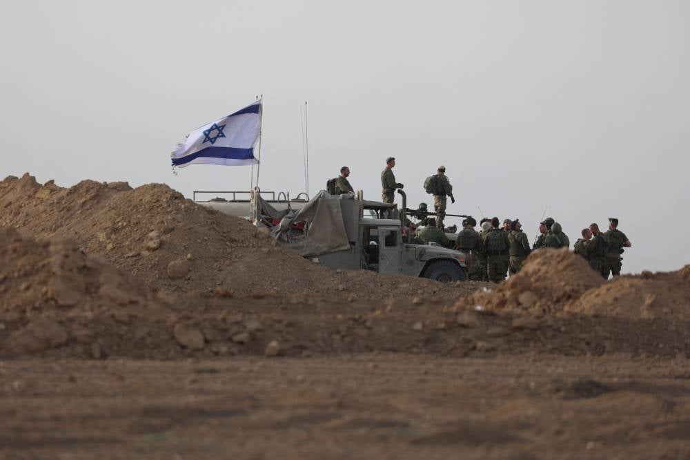 Israeli troops gather near the border with Gaza before entering the Palestinian strip on Oct 29. Photo by Gil Cohen-Magen/AFP