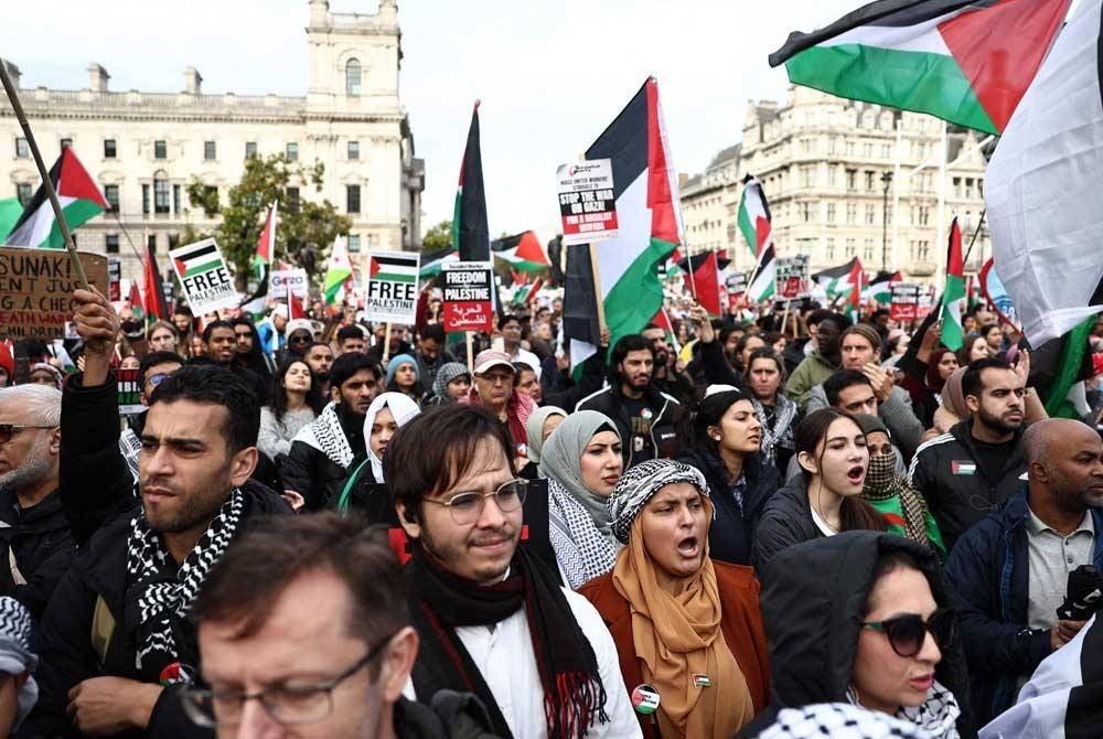 The public holding banners and waving the Palestinian flag during the 'March for Palestine' on Saturday. - AFP