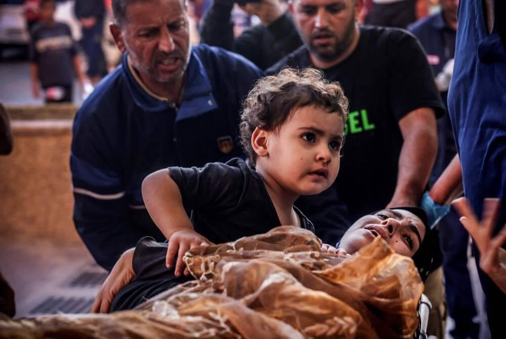 A wounded Palestinian woman and her child are wheeled into the Nasser hospital following Israeli bombardment, in Khan Yunis, in the southern Gaza Strip on Oct 26. (Photo by MOHAMMED ABED / AFP)